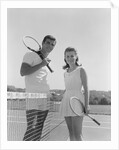 Portrait tennis couple man woman holding racquets standing by net by Anonymous