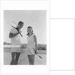 Portrait tennis couple man woman holding racquets standing by net by Anonymous