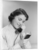 Young woman talking on telephone reading address from little black book by Anonymous