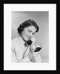 Young woman talking on telephone reading address from little black book by Anonymous