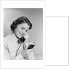 Young woman talking on telephone reading address from little black book by Anonymous