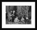 Family christmas photo father two daughters and son with presents and tree by Anonymous