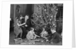 Family christmas photo father two daughters and son with presents and tree by Anonymous
