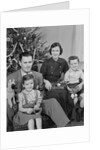 Family portrait by christmas tree by Anonymous