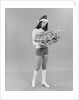 Young woman wearing santa claus hat hot pants go-go boots holding wrapped christmas presents by Anonymous