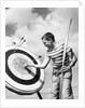 Boy jeans striped t-shirt holding bow & pulling arrow out of target bull's-eye by Anonymous