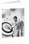 Boy jeans striped t-shirt holding bow & pulling arrow out of target bull's-eye by Anonymous
