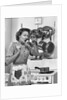 Housewife tasting with spoon by stove funny facial expression by Anonymous