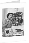 Housewife tasting with spoon by stove funny facial expression by Anonymous