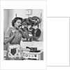 Housewife tasting with spoon by stove funny facial expression by Anonymous