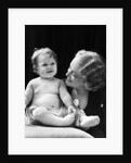 Blond woman mother smiling looking at baby sitting on pillow by Anonymous