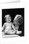 Blond woman mother smiling looking at baby sitting on pillow by Anonymous