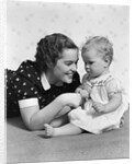 Woman mother smiling sitting playing with baby daughter by Anonymous