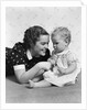 Woman mother smiling sitting playing with baby daughter by Anonymous