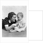 Woman mother smiling sitting playing with baby daughter by Anonymous