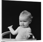 Baby in high chair making shrugging gesture by Anonymous