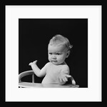 Baby in high chair making shrugging gesture by Anonymous
