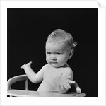 Baby in high chair making shrugging gesture by Anonymous