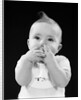Portrait of baby covering mouth with hands fingers by Anonymous