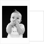 Portrait of baby covering mouth with hands fingers by Anonymous