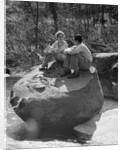 Couple man woman sitting on large rock in stream hugging knees smiling happy romance by Anonymous