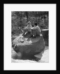 Couple man woman sitting on large rock in stream hugging knees smiling happy romance by Anonymous