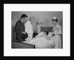 Doctor nurse husband talking with female patient in hospital bed by Anonymous