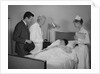Doctor nurse husband talking with female patient in hospital bed by Anonymous