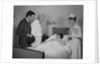 Doctor nurse husband talking with female patient in hospital bed by Anonymous