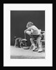 Toddler sitting in chair pouring milk from bottle into bowl for puppy dog by Anonymous
