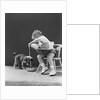 Toddler sitting in chair pouring milk from bottle into bowl for puppy dog by Anonymous