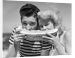 Teen age boy & girl eating slice watermelon by Anonymous