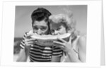 Teen age boy & girl eating slice watermelon by Anonymous