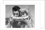 Teen age boy & girl eating slice watermelon by Anonymous