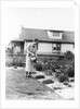 Woman watering garden with water can by Anonymous