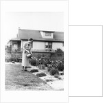 Woman watering garden with water can by Anonymous