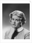 Blonde woman fist to chin worried serious facial expression by Anonymous