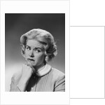 Blonde woman fist to chin worried serious facial expression by Anonymous