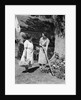 Two women talking in yard one holding garden hoe the other holds basket with flowers by Anonymous