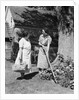 Two women talking in yard one holding garden hoe the other holds basket with flowers by Anonymous