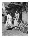 Two women talking in yard one holding garden hoe the other holds basket with flowers by Anonymous