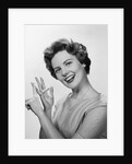 Smiling woman counting on fingers wearing pearls by Anonymous