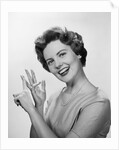 Smiling woman counting on fingers wearing pearls by Anonymous