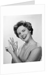 Smiling woman counting on fingers wearing pearls by Anonymous