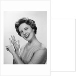 Smiling woman counting on fingers wearing pearls by Anonymous