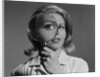 Blond woman magnifying glass held up to and enlarging one eye by Anonymous