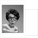 Portrait brunette wearing dark thick round eyeglasses with eyes wide open by Anonymous