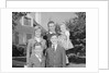 Family portrait father mother two sons and daughter in front of suburban house by Anonymous