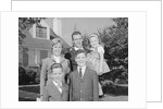 Family portrait father mother two sons and daughter in front of suburban house by Anonymous