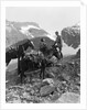 Couple man woman wearing riding gear jodhpurs boots spurs sitting standing on large rock by two horses by Anonymous